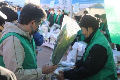 生産者からブランドねぎを買う来場者